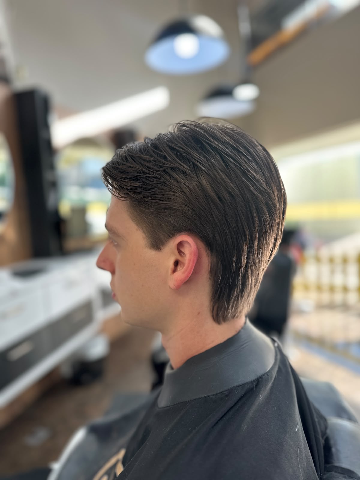 Corte na tesoura com acabamento na nuca, visto de perfil